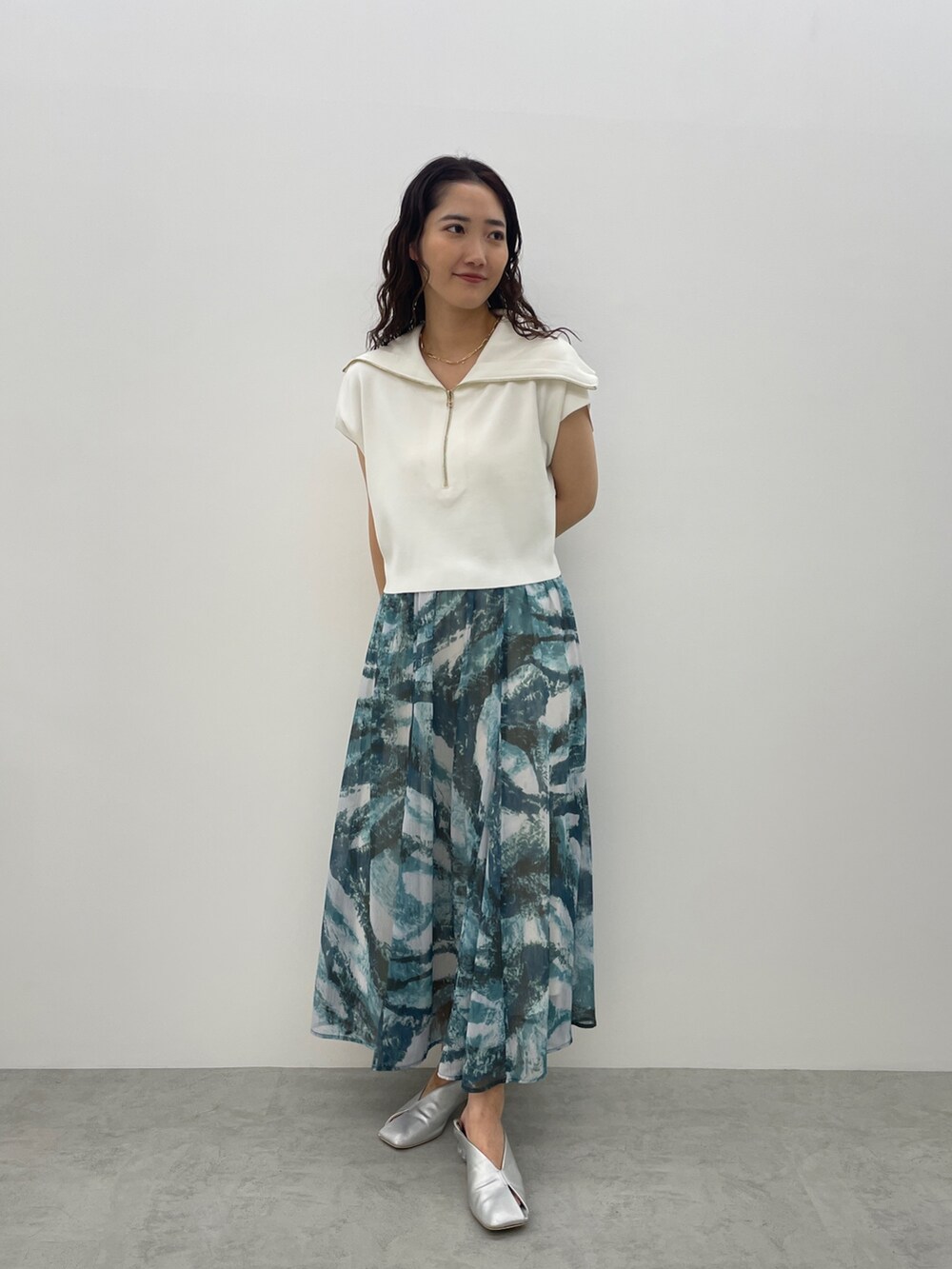 シルバー系のパンプス、ブルー系のスカート、ホワイト系のTシャツ/カットソーを着用したレディースの春コーディネートの3枚目の写真