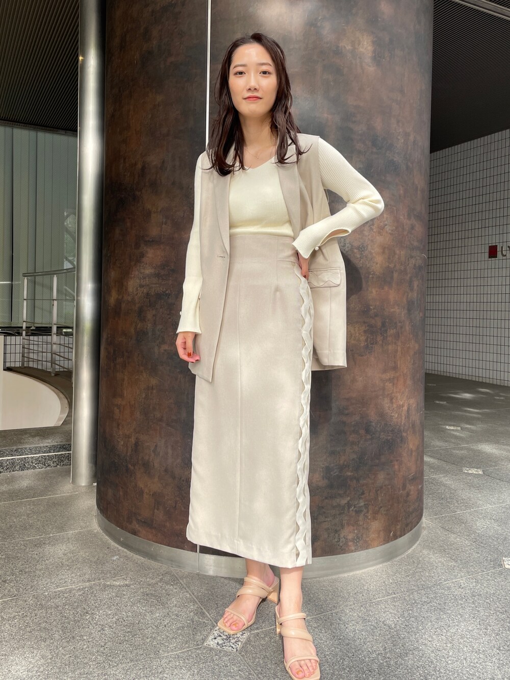 ベージュ系のサンダル、ベージュ系のスカート、ホワイト系のニット/セーターを着用したレディースの冬コーディネートの3枚目の写真