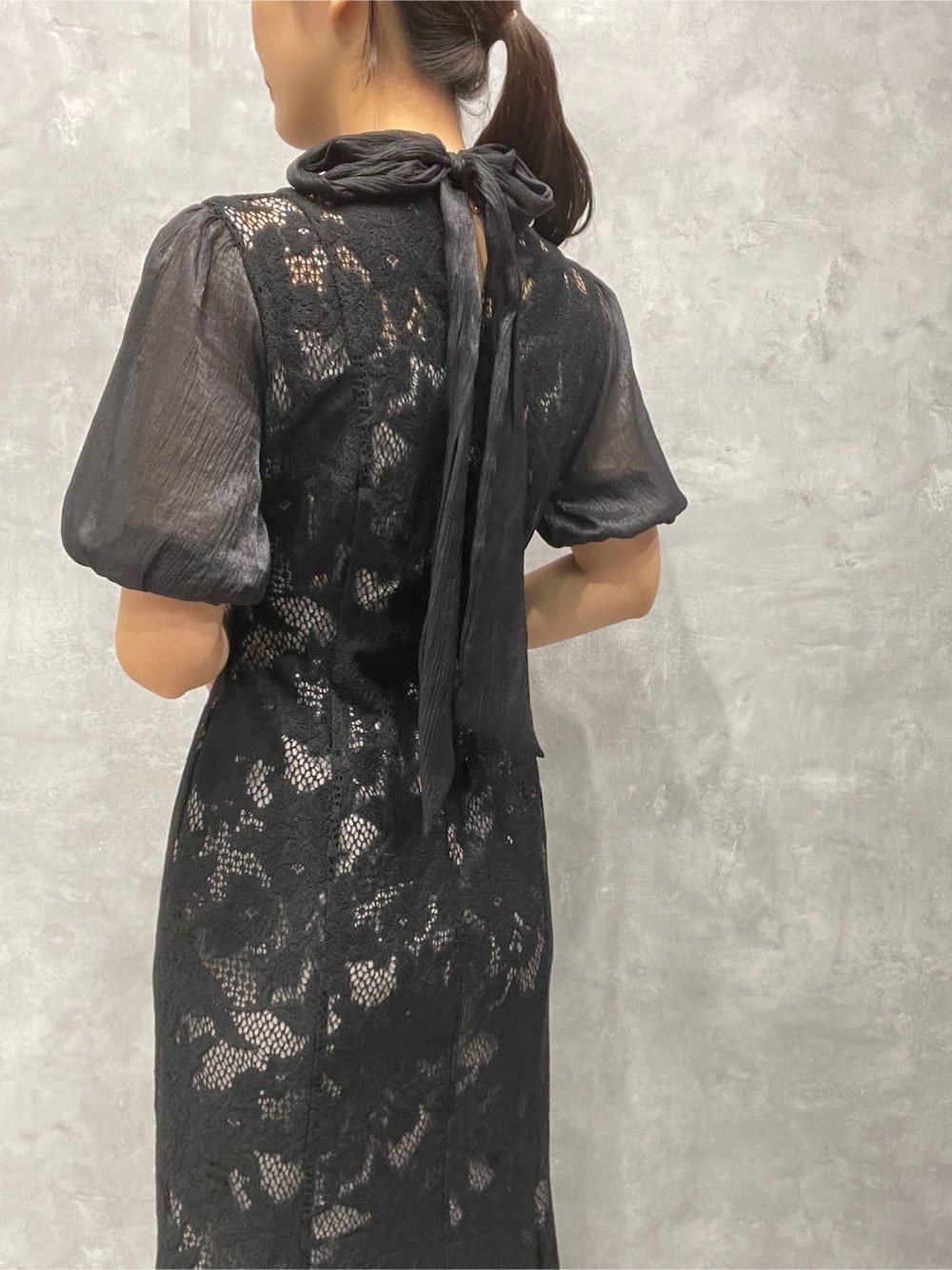 ゴールド系のパンプス、ゴールド系のクラッチバッグ、ブラック系のドレスを着用したレディースの秋コーディネートの9枚目の写真