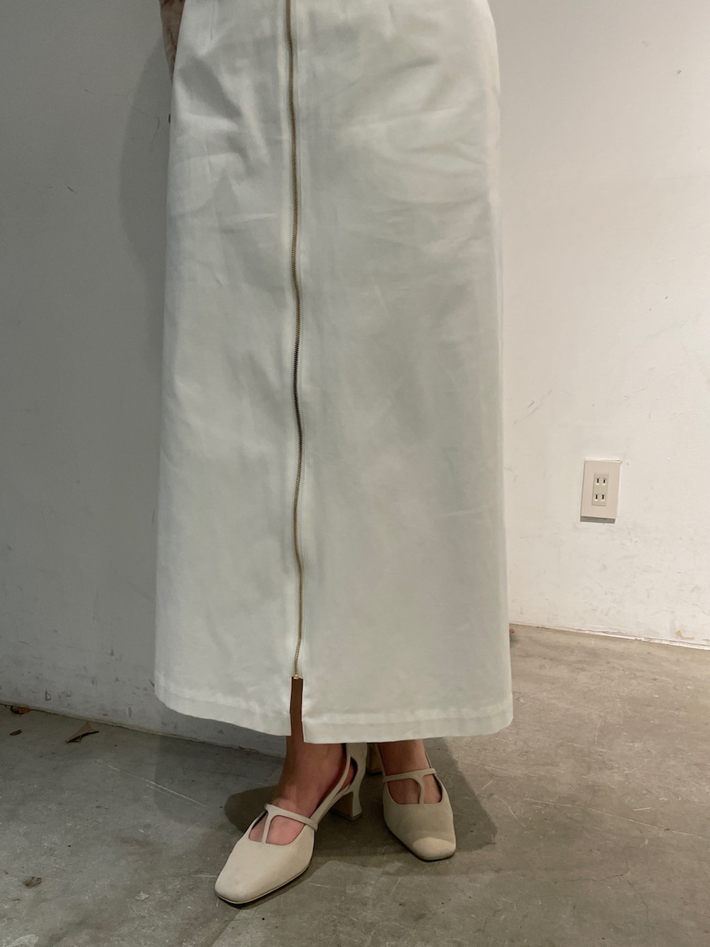 ホワイト系のパンプス、イエロー系のTシャツ/カットソー、ホワイト系のジャンパースカートを着用したレディースの冬コーディネートの8枚目の写真