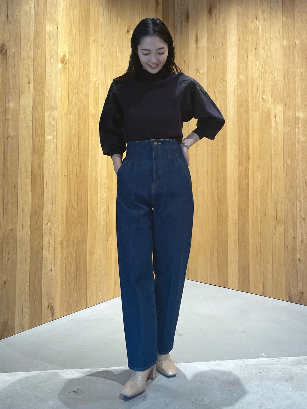 ベージュ系のブーツ、グレー系のニット/セーター、ブルー系のデニムパンツを着用したレディースの秋コーディネートの3枚目の写真