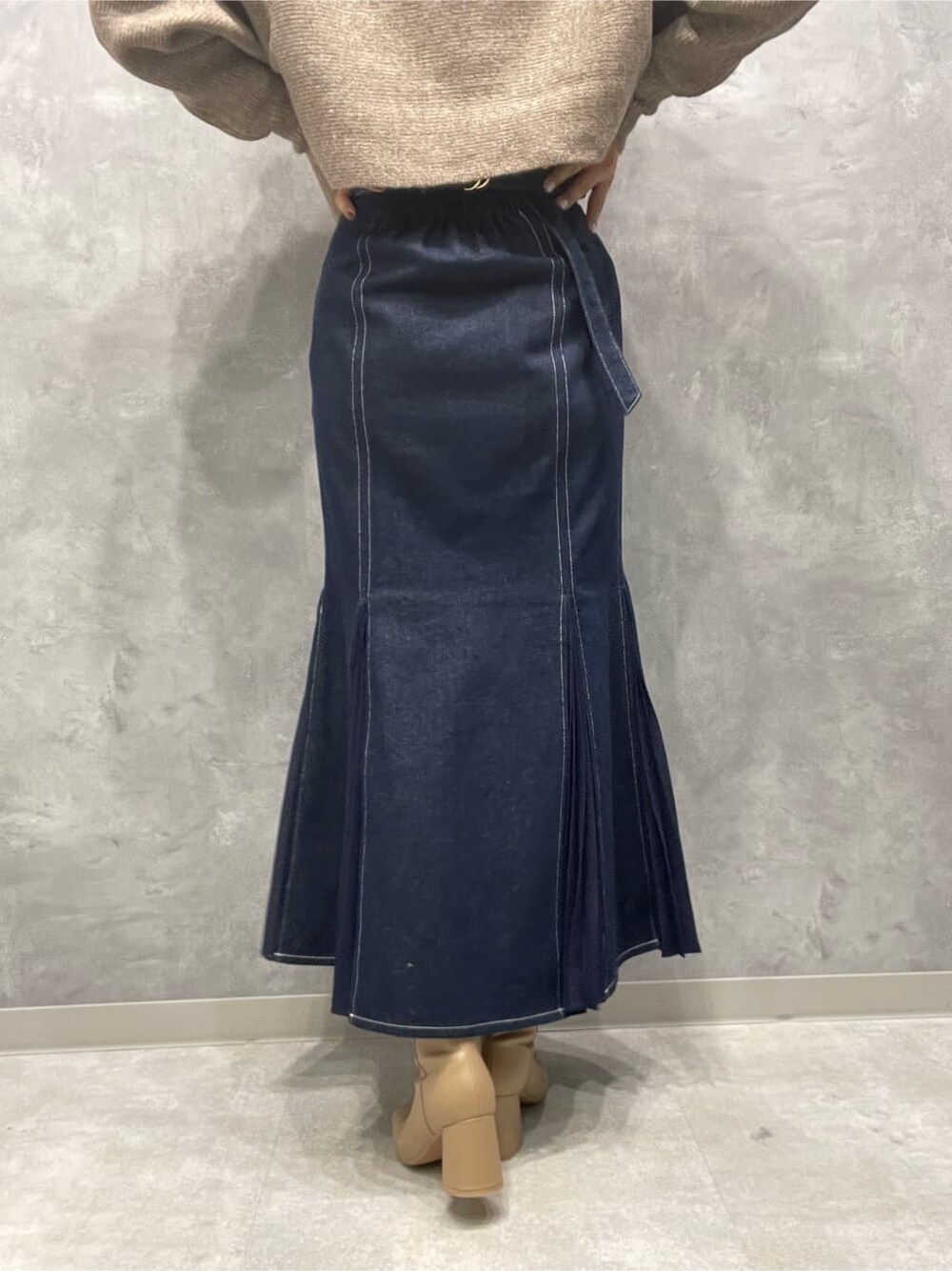 ベージュ系のブーツ、ブルー系のスカート、ベージュ系のカーディガン/ボレロを着用したレディースの秋コーディネートの9枚目の写真