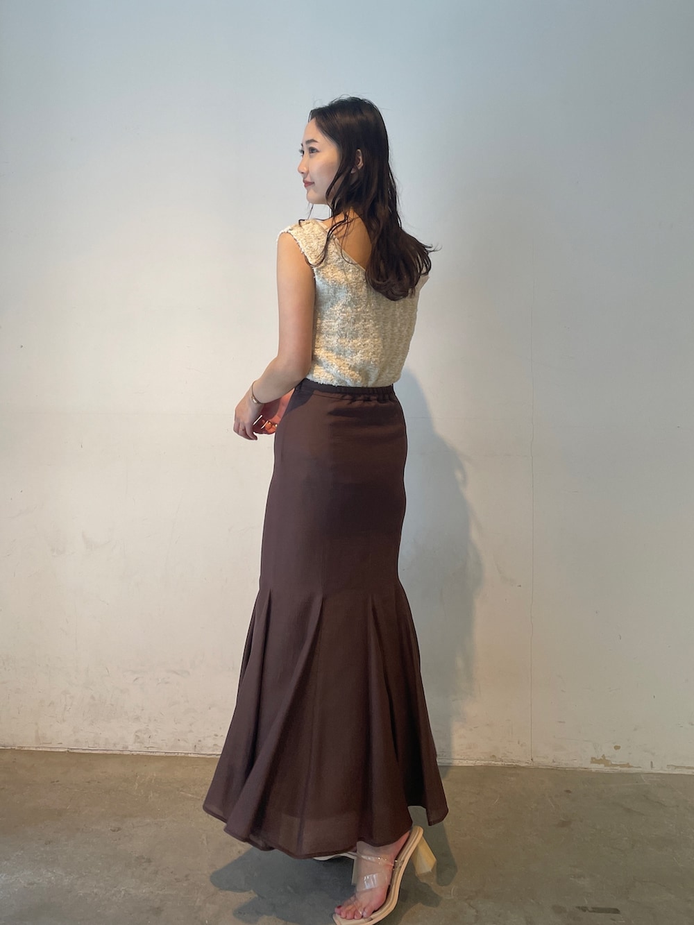 その他のサンダル、ホワイト系のニット/セーター、ブラウン系のスカートを着用したレディースの春コーディネートの3枚目の写真