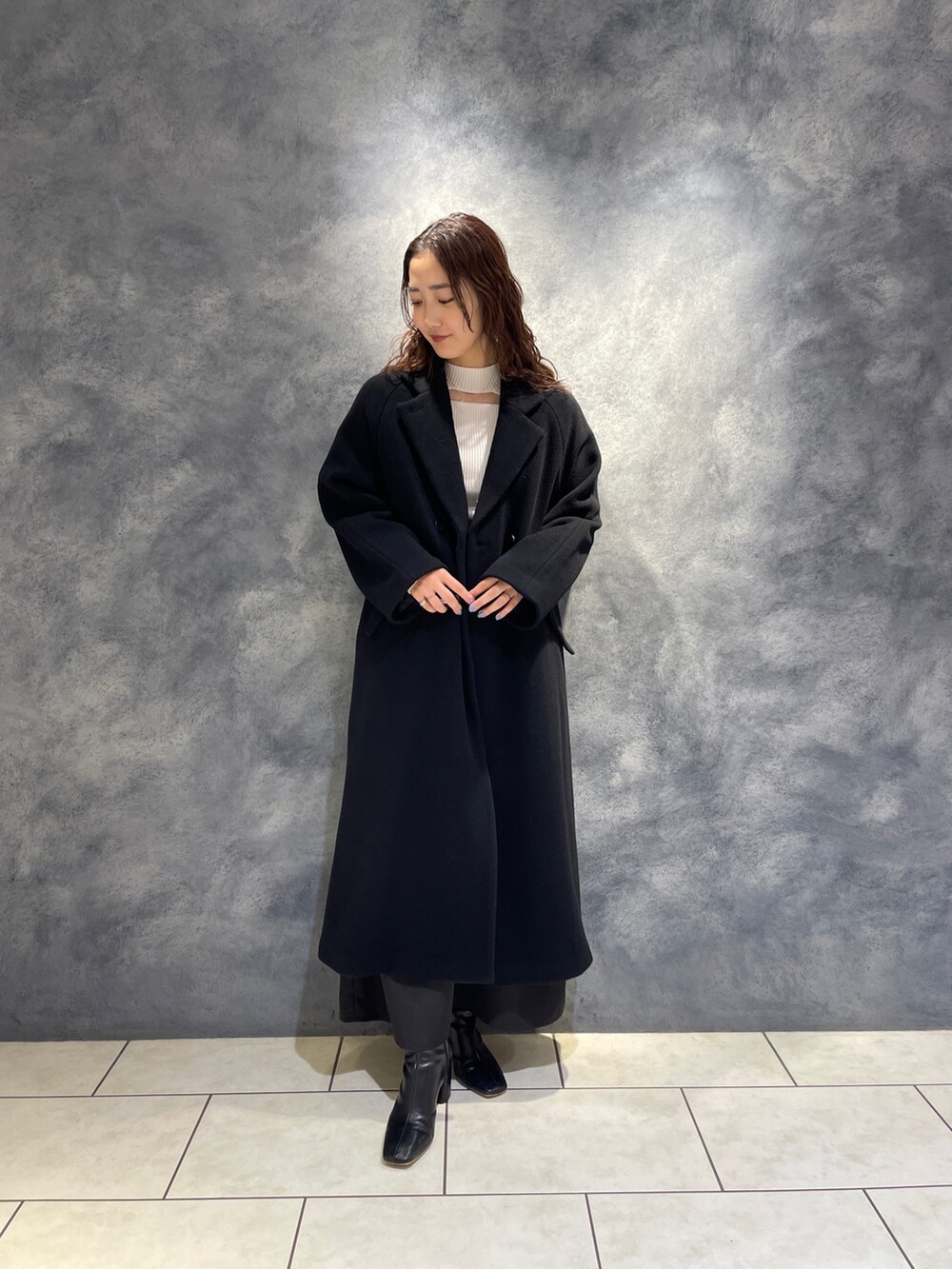 ブラック系のスカート、ホワイト系のニット/セーター、ブラック系のブーツを着用したレディースの秋コーディネートの8枚目の写真