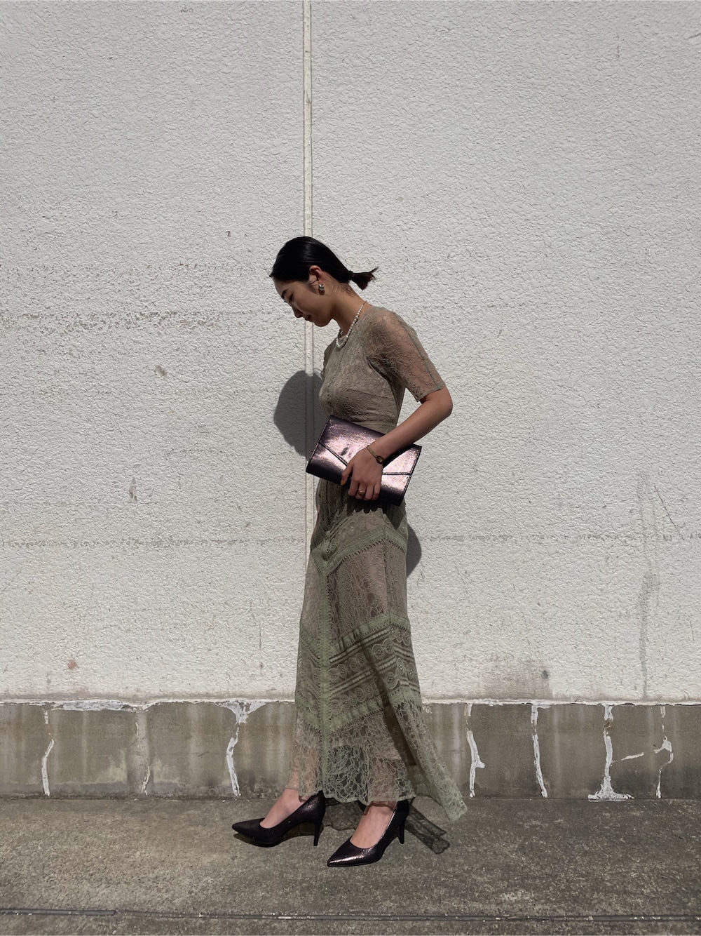 グリーン系のドレスを着用したレディースの春コーディネートの3枚目の写真