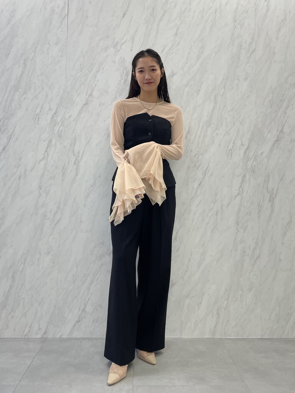 ベージュ系のパンプス、ブラック系のパンツドレス、ホワイト系のTシャツ/カットソーを着用したレディースの秋コーディネートの2枚目の写真