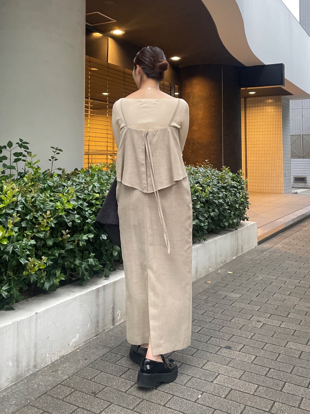 ベージュ系のワンピース、ホワイト系のニット/セーター、ブラック系のローファーを着用したレディースの秋コーディネートの5枚目の写真