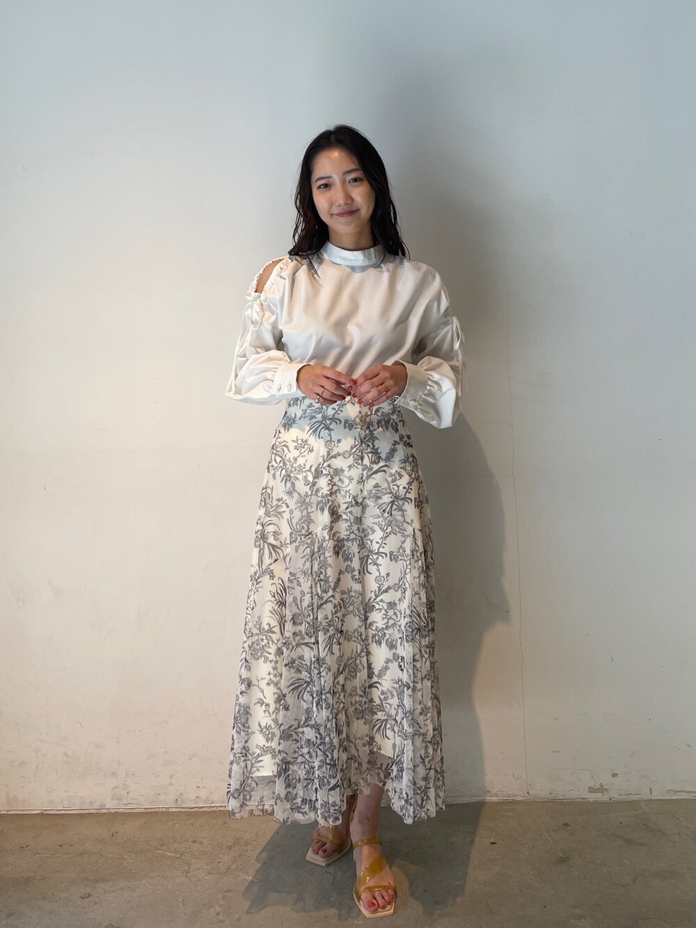 ホワイト系のシャツ/ブラウス、ホワイト系のスカート、イエロー系のサンダルを着用したレディースの冬コーディネートの3枚目の写真