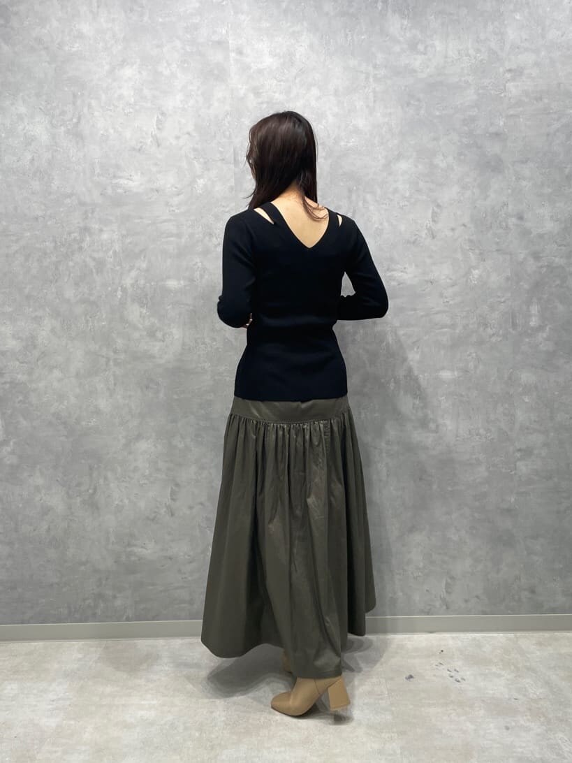 ベージュ系のスカート、ベージュ系のブーツ、ブラック系のニット/セーターを着用したレディースの秋コーディネートの6枚目の写真