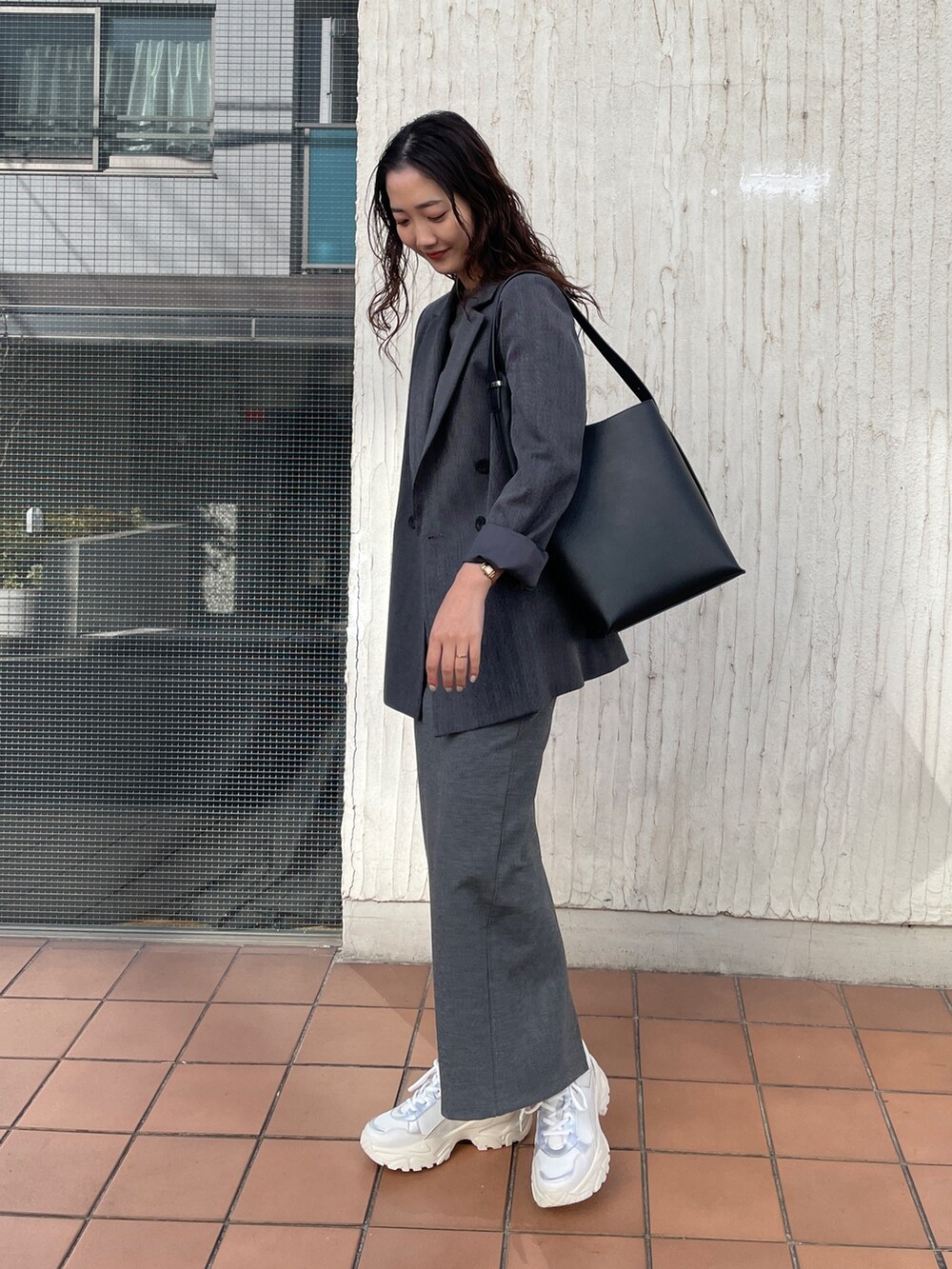 ホワイト系のスニーカー、グレー系のワンピース、グレー系のテーラードジャケットを着用したレディースの冬コーディネートの3枚目の写真