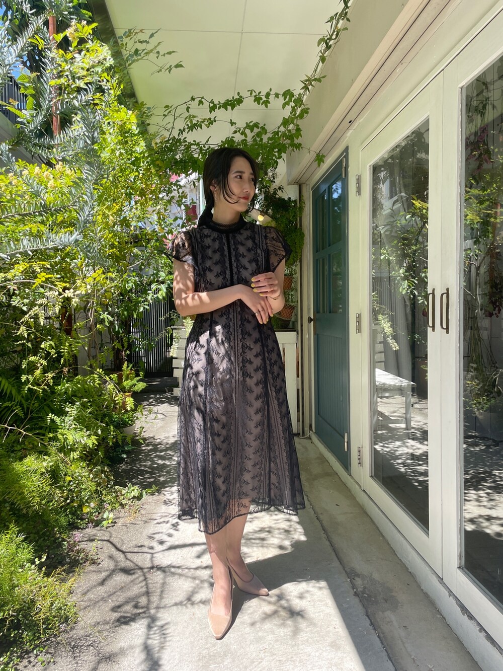 ゴールド系のパンプス、ブラック系のドレスを着用したレディースの夏コーディネートの3枚目の写真