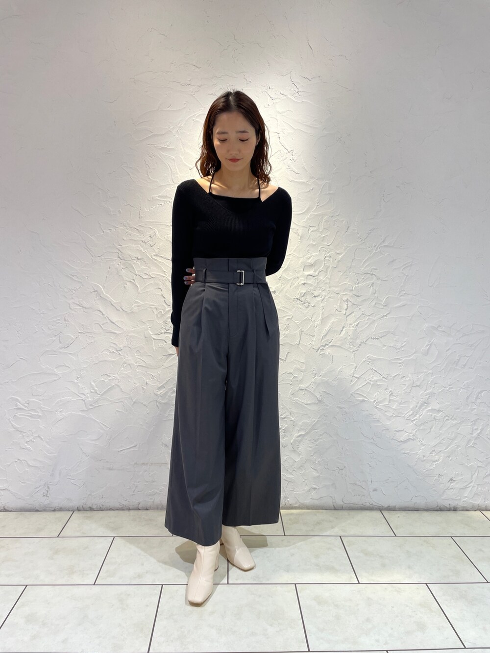 グレー系のその他パンツ、ブラック系のニット/セーター、ホワイト系のブーツを着用したレディースの冬コーディネートの2枚目の写真