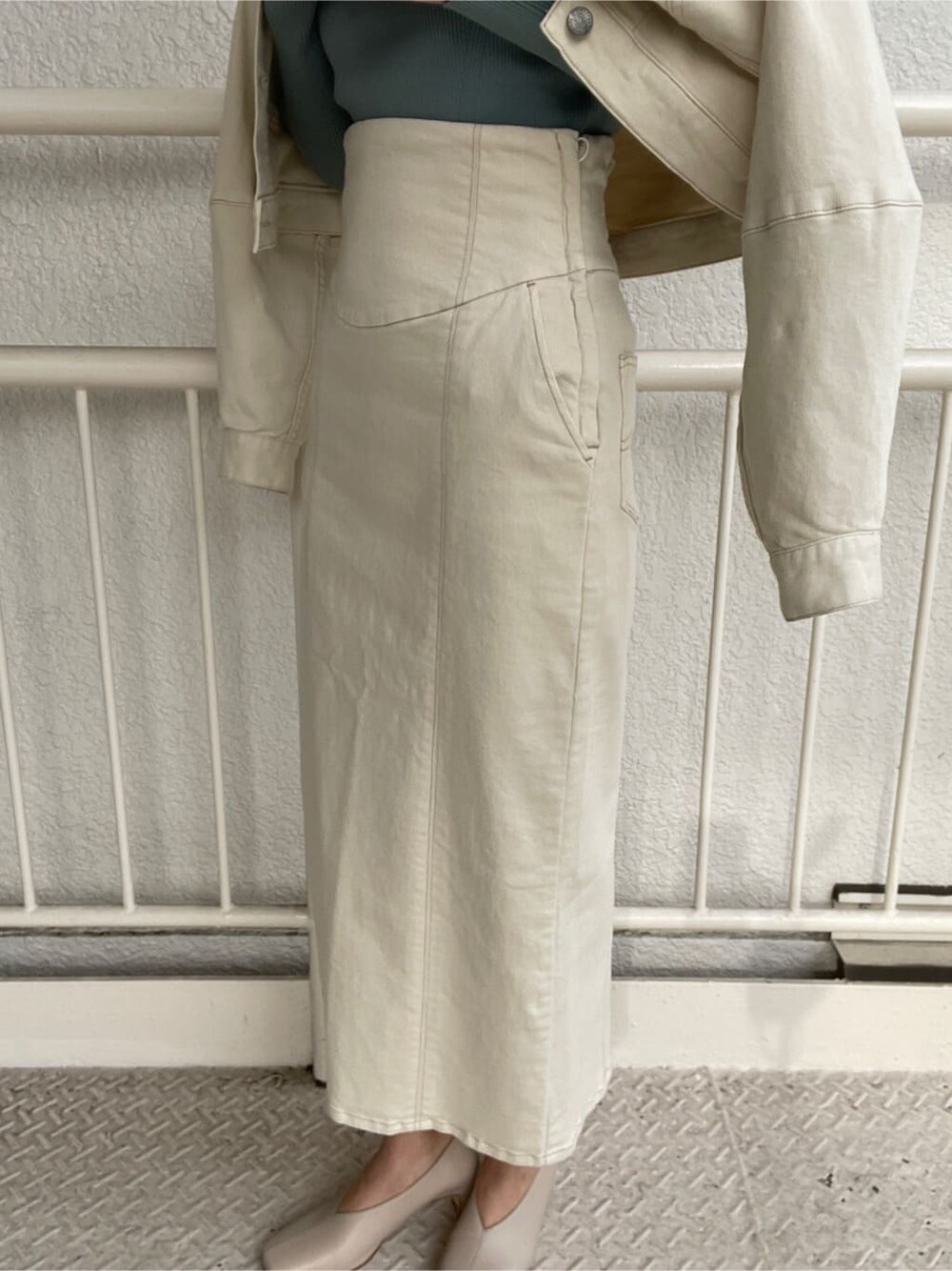 ホワイト系のブルゾン、ホワイト系のスカート、ホワイト系のパンプスを着用したレディースの冬コーディネートの3枚目の写真