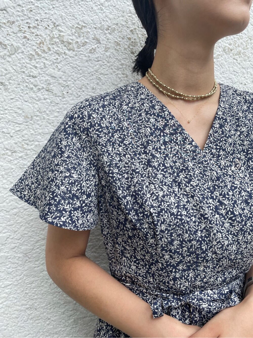 ベージュ系のハンドバッグ、ブルー系のワンピース、ゴールド系のネックレスを着用したレディースの夏コーディネートの5枚目の写真