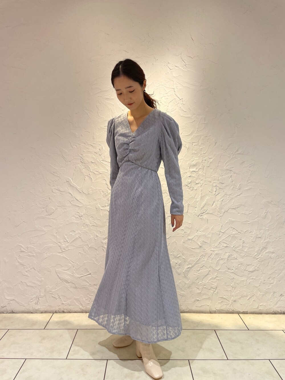 ホワイト系のブーツ、ブルー系のワンピースを着用したレディースの冬コーディネートの3枚目の写真