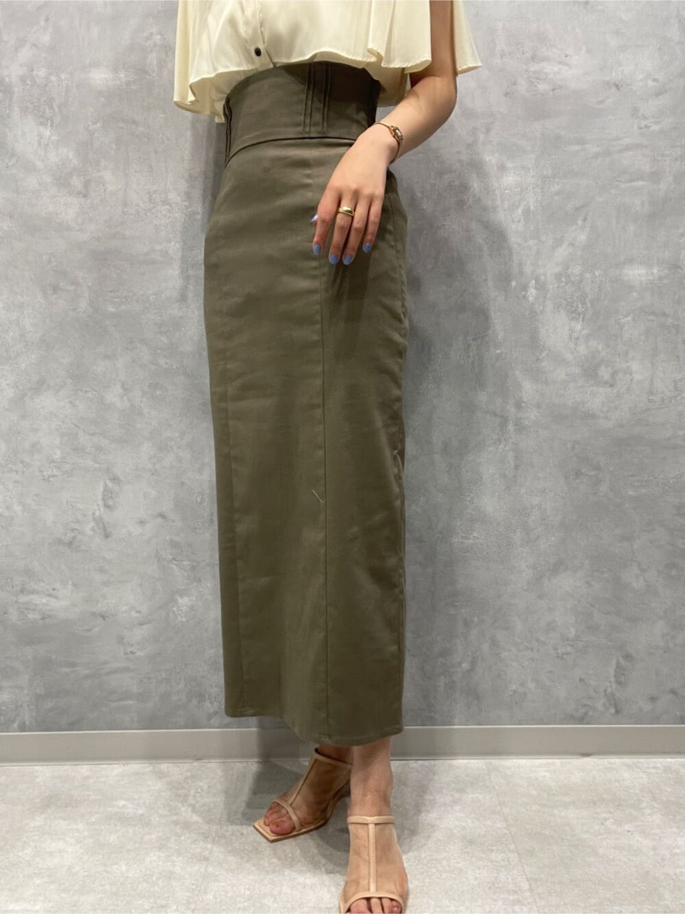 ベージュ系のスカート、ベージュ系のサンダル、ホワイト系のシャツ/ブラウスを着用したレディースの夏コーディネートの8枚目の写真