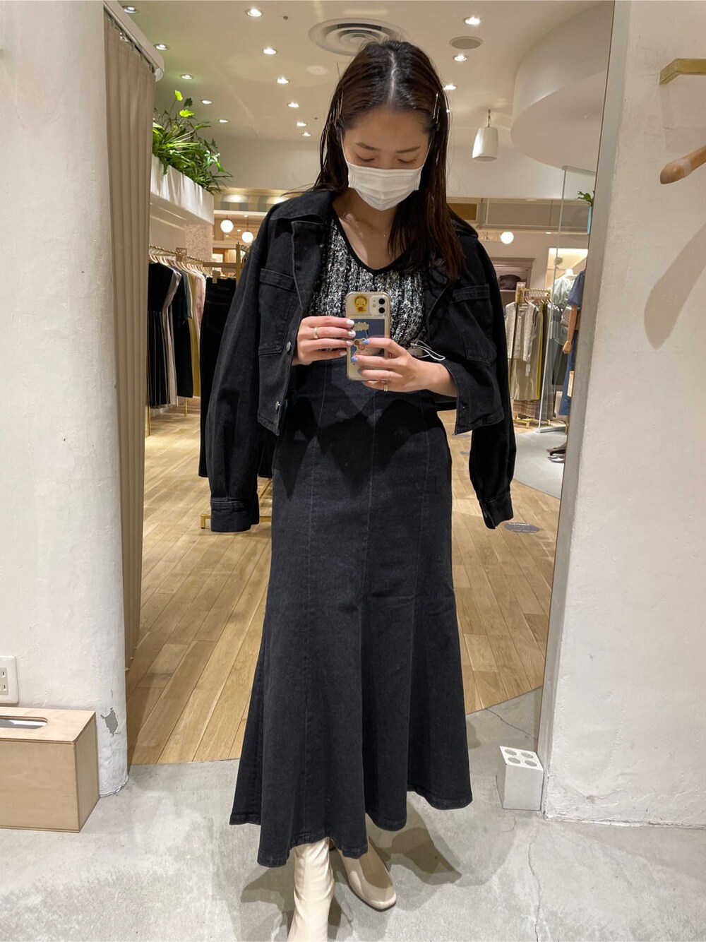 ブラック系のスカート、ブラック系のデニムジャケット、ブラック系のニット/セーターを着用したレディースの夏コーディネートの2枚目の写真