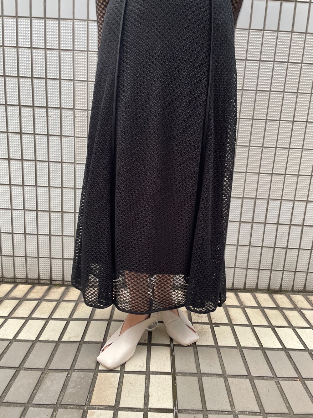 ホワイト系のパンプス、ブラック系のワンピースを着用したレディースの冬コーディネートの9枚目の写真