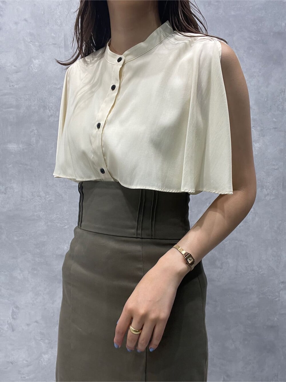 ベージュ系のスカート、ベージュ系のサンダル、ホワイト系のシャツ/ブラウスを着用したレディースの夏コーディネートの6枚目の写真