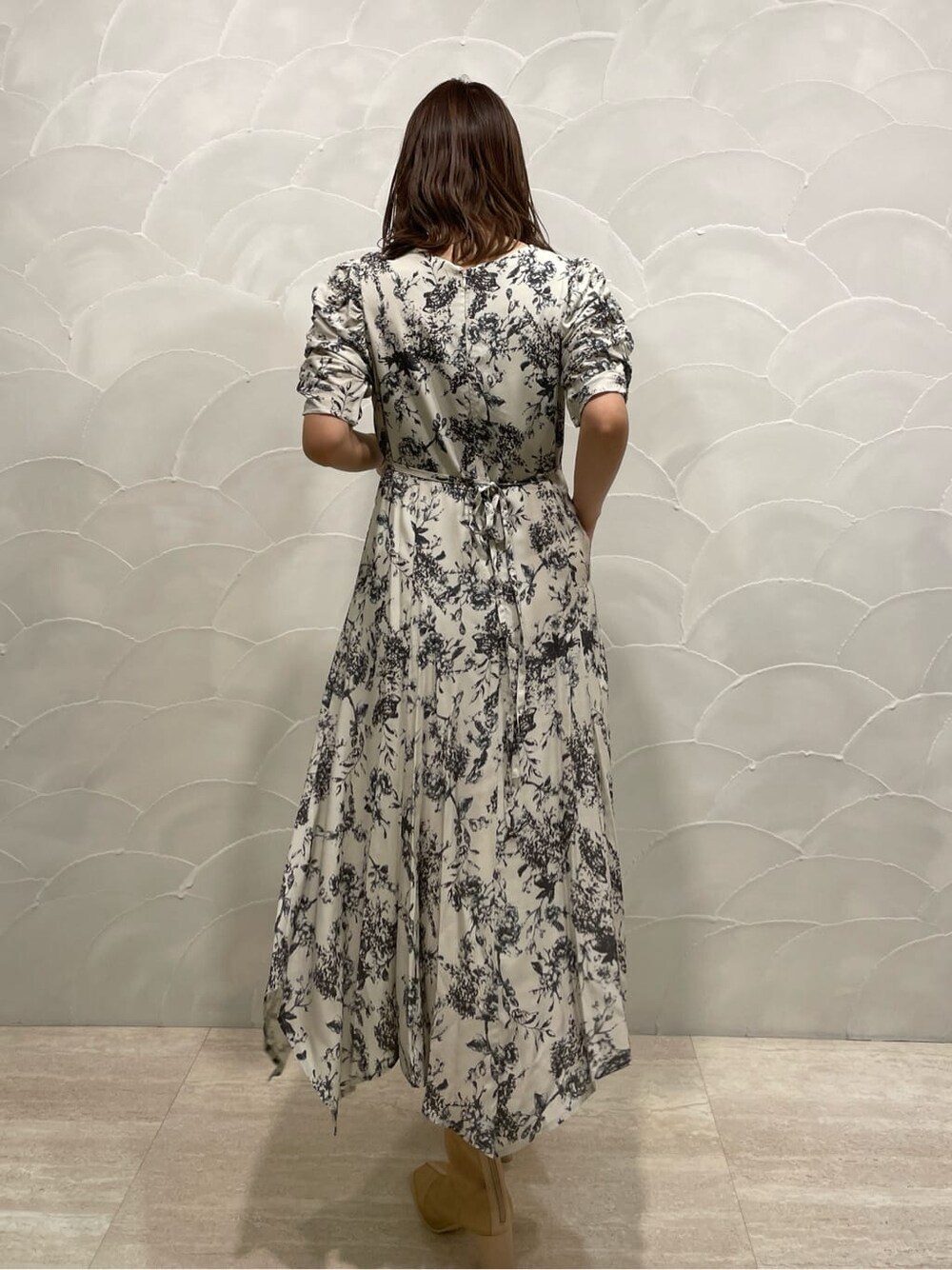 パープル系のテーラードジャケット、ベージュ系のブーツ、グレー系のワンピースを着用したレディースの春コーディネートの6枚目の写真