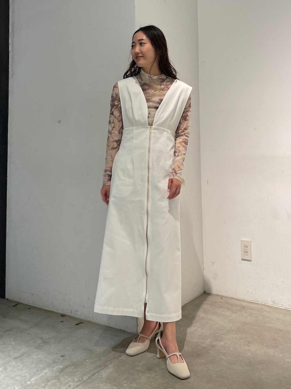 ホワイト系のパンプス、イエロー系のTシャツ/カットソー、ホワイト系のジャンパースカートを着用したレディースの冬コーディネートの3枚目の写真