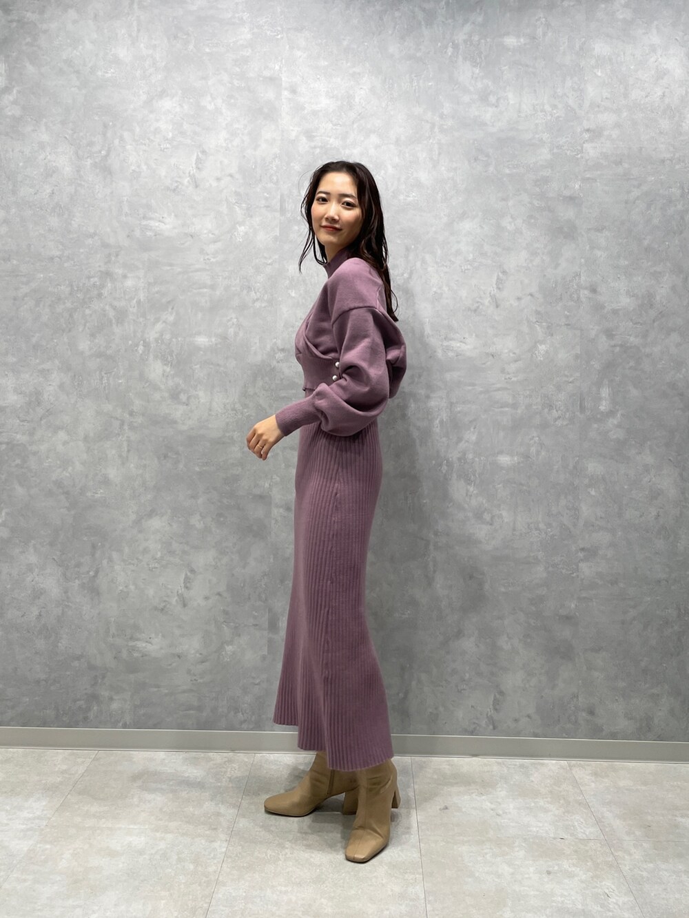 ブラウン系のその他アウター、ベージュ系のブーツ、パープル系のワンピースを着用したレディースの冬コーディネートの7枚目の写真