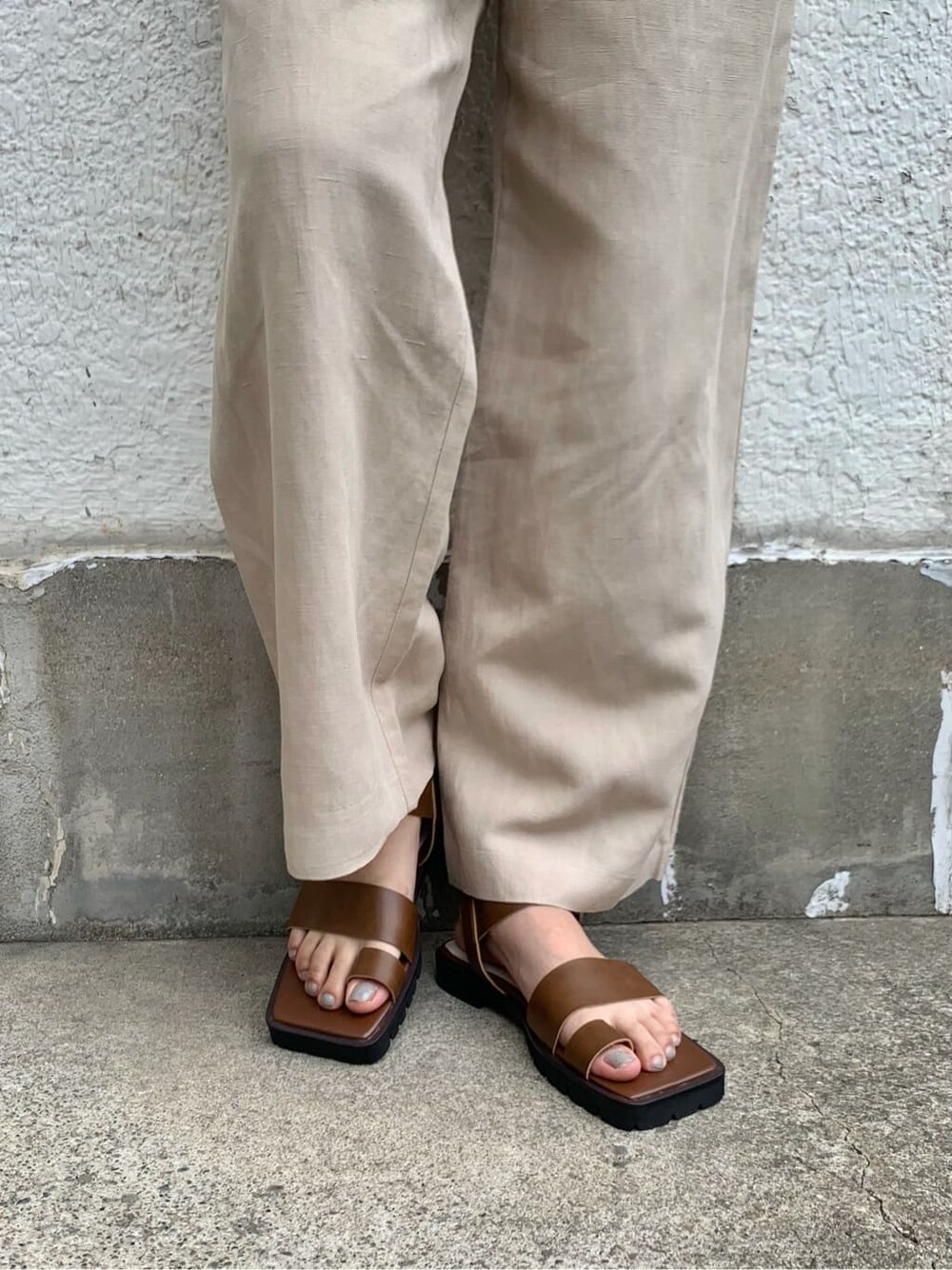 ブラウン系のサンダル、ホワイト系のニット/セーター、ベージュ系のその他パンツを着用したレディースの夏コーディネートの7枚目の写真