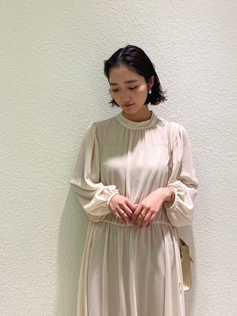 ベージュ系のハンドバッグ、ベージュ系のサンダル、ホワイト系のワンピースを着用したレディースの冬コーディネートの6枚目の写真