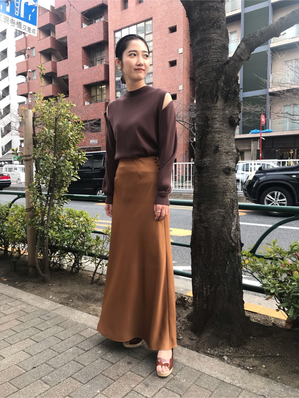 ブラウン系のスカート、ブラウン系のパンプス、ブラウン系のニット/セーターを着用したレディースの冬コーディネートの2枚目の写真