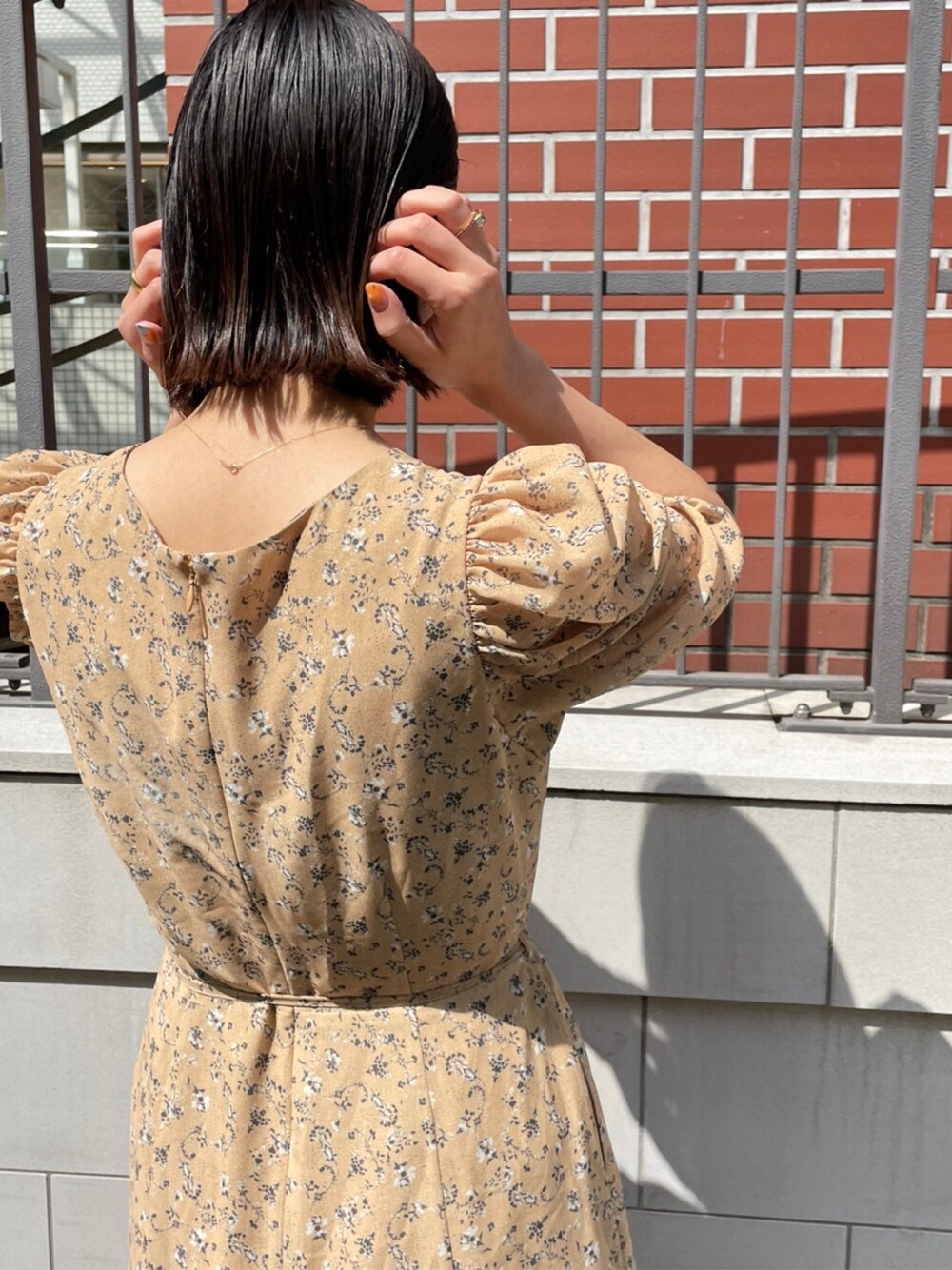 イエロー系のワンピース、その他のパンプスを着用したレディースの春コーディネートの3枚目の写真