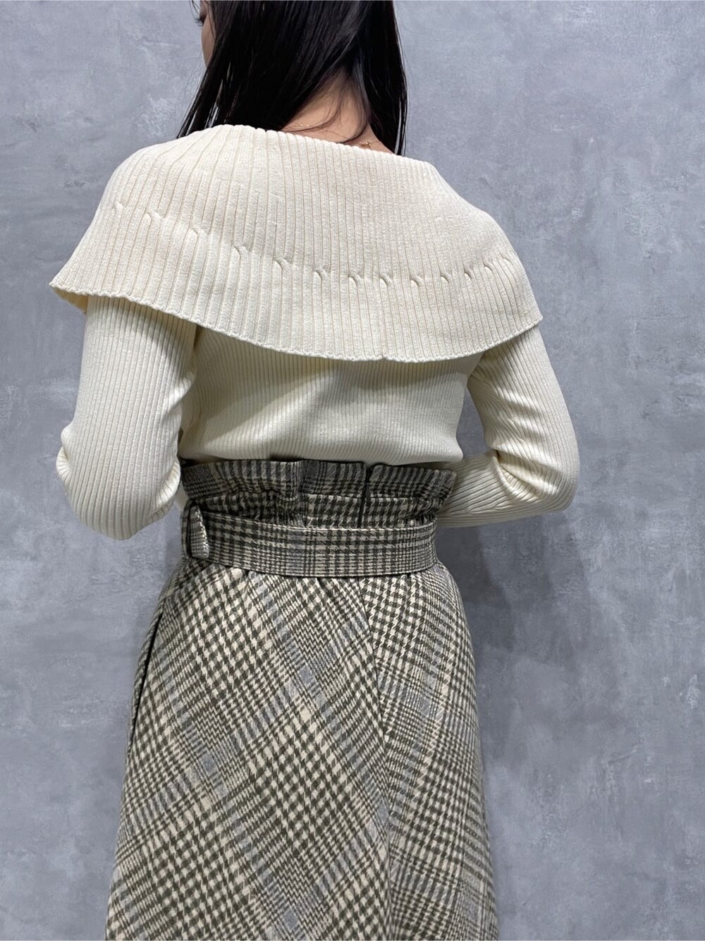 ブラック系のブーツ、ベージュ系のスカート、ホワイト系のニット/セーターを着用したレディースの秋コーディネートの8枚目の写真