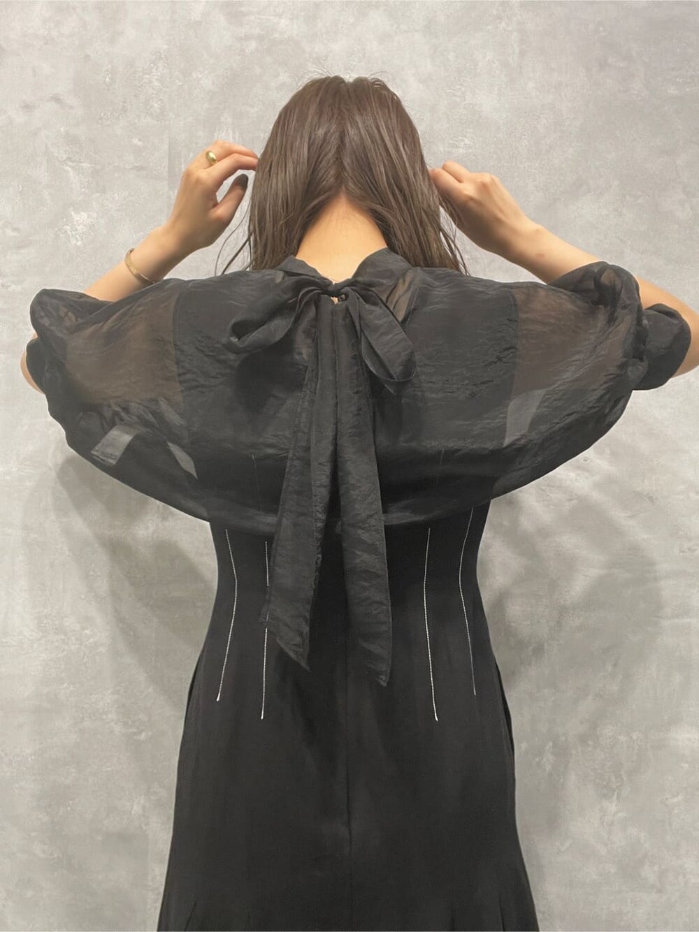 ブラウン系のサンダル、ホワイト系のハンドバッグ、ブラック系のワンピースを着用したレディースの夏コーディネートの7枚目の写真