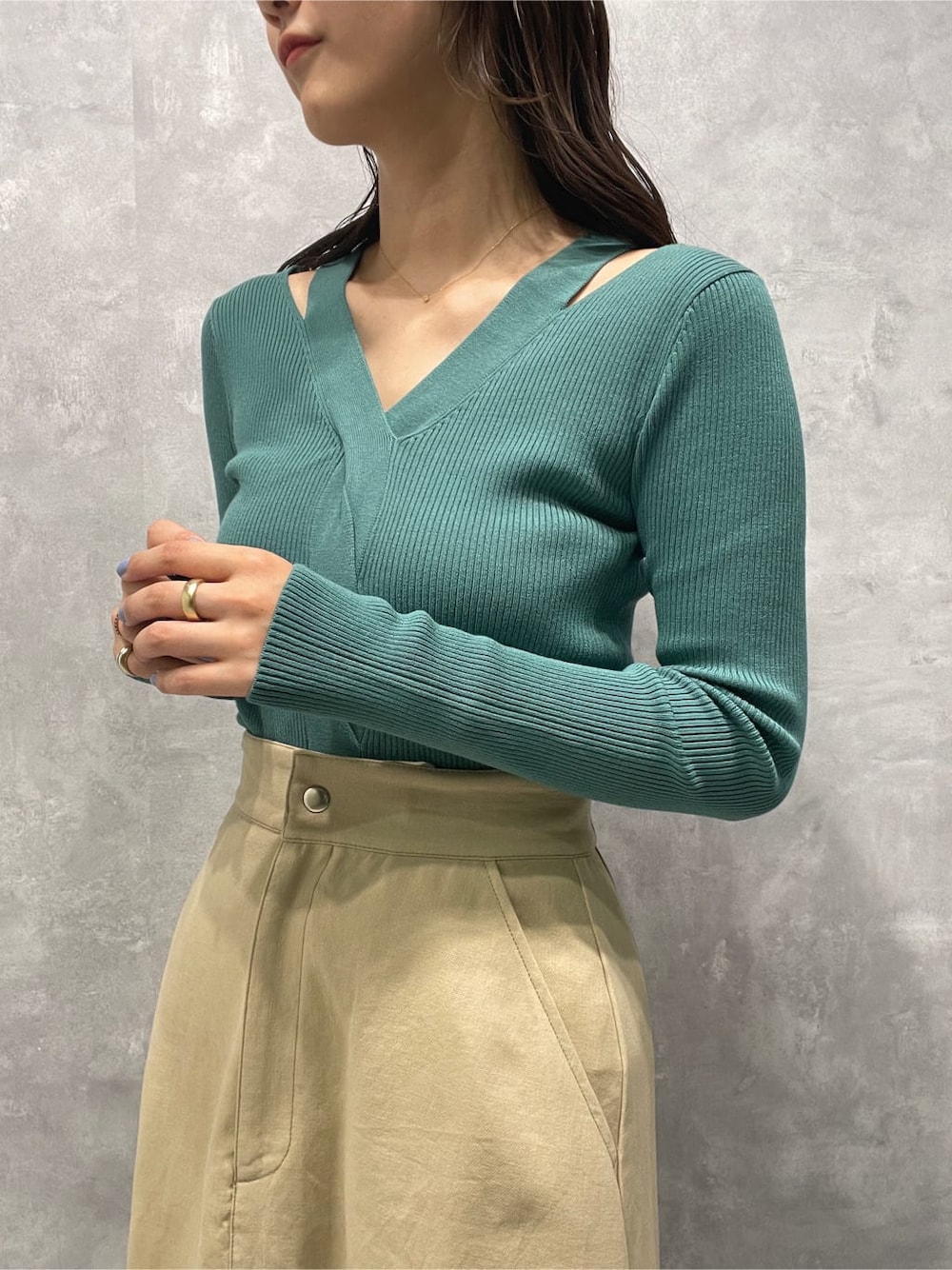 ベージュ系のスカート、ベージュ系のブーツ、グリーン系のニット/セーターを着用したレディースの夏コーディネートの8枚目の写真