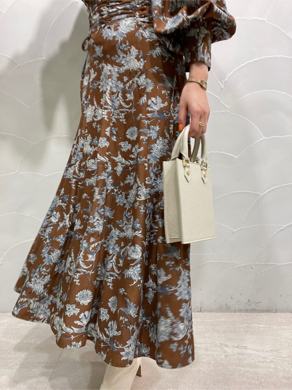 ホワイト系のその他シューズ、ホワイト系のショルダーバッグ、ブラウン系のワンピースを着用したレディースの冬コーディネートの8枚目の写真