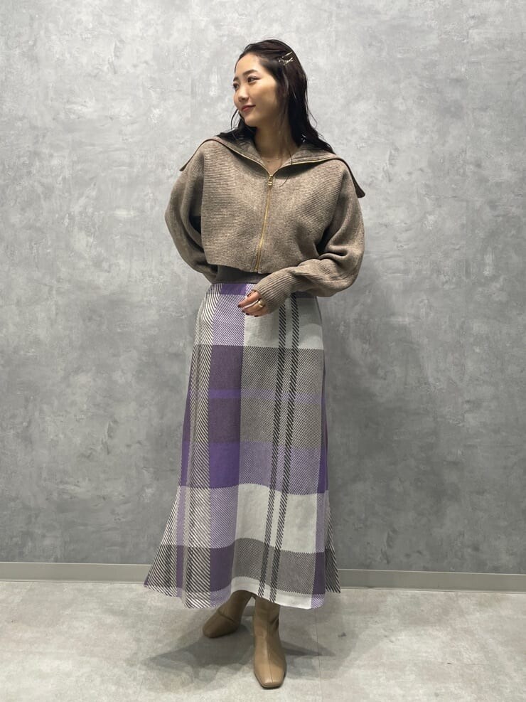 ベージュ系のブーツ、ベージュ系のカーディガン/ボレロ、パープル系のスカートを着用したレディースの秋コーディネートの4枚目の写真