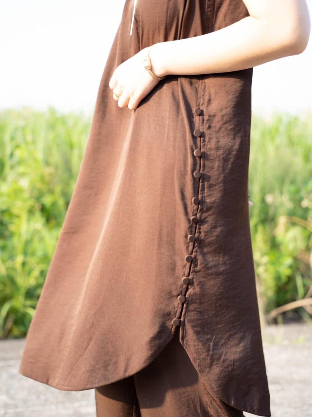 ブラウン系のワンピース、シルバー系のバングル/リストバンドを着用したレディースの夏コーディネートの3枚目の写真