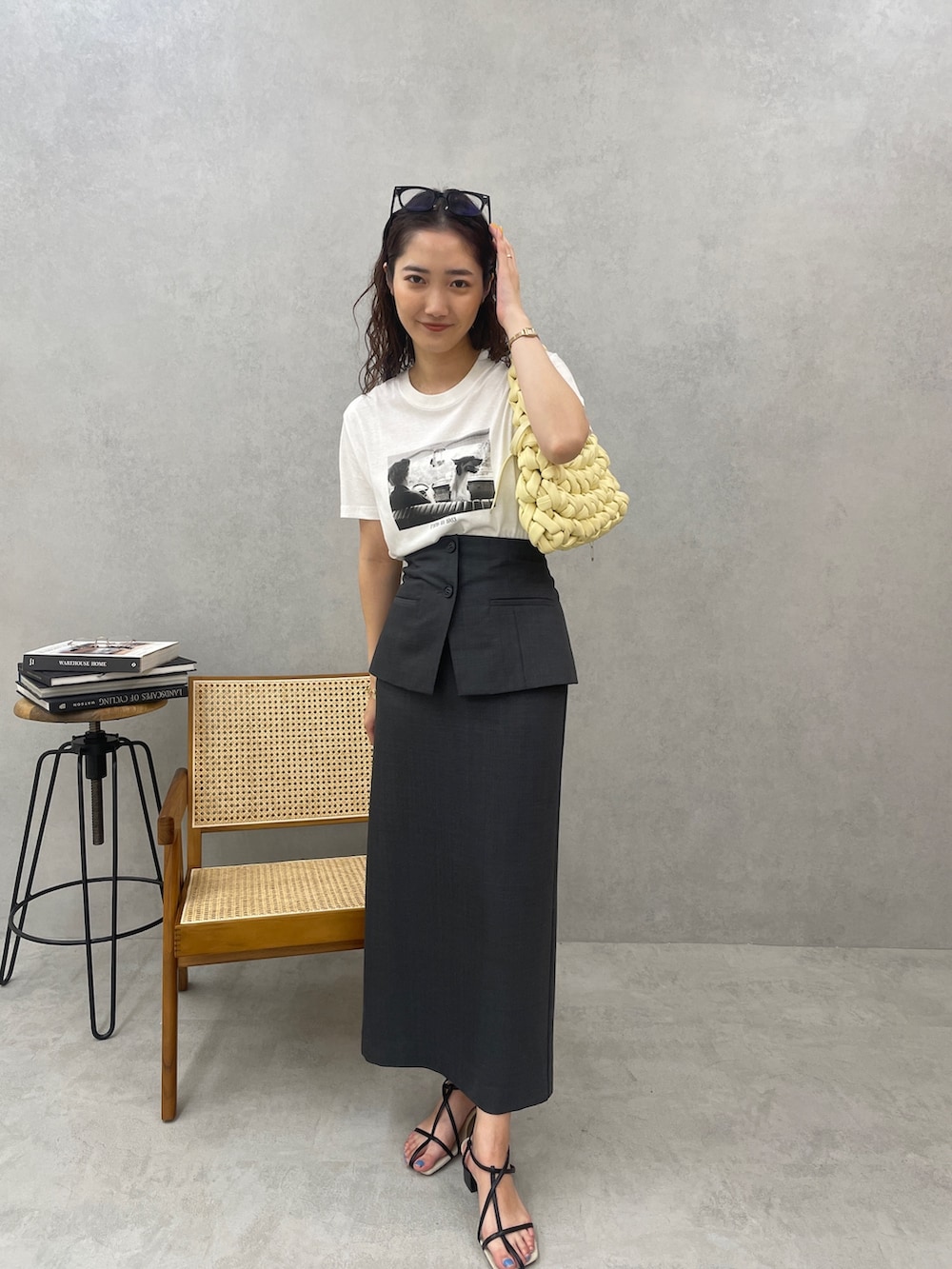 ベージュ系のハンドバッグ、ブラック系のサンダル、ホワイト系のTシャツ/カットソーを着用したレディースの春コーディネートの6枚目の写真