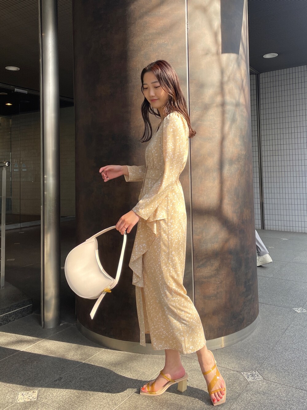 ベージュ系のワンピース、イエロー系のサンダルを着用したレディースの冬コーディネートの3枚目の写真