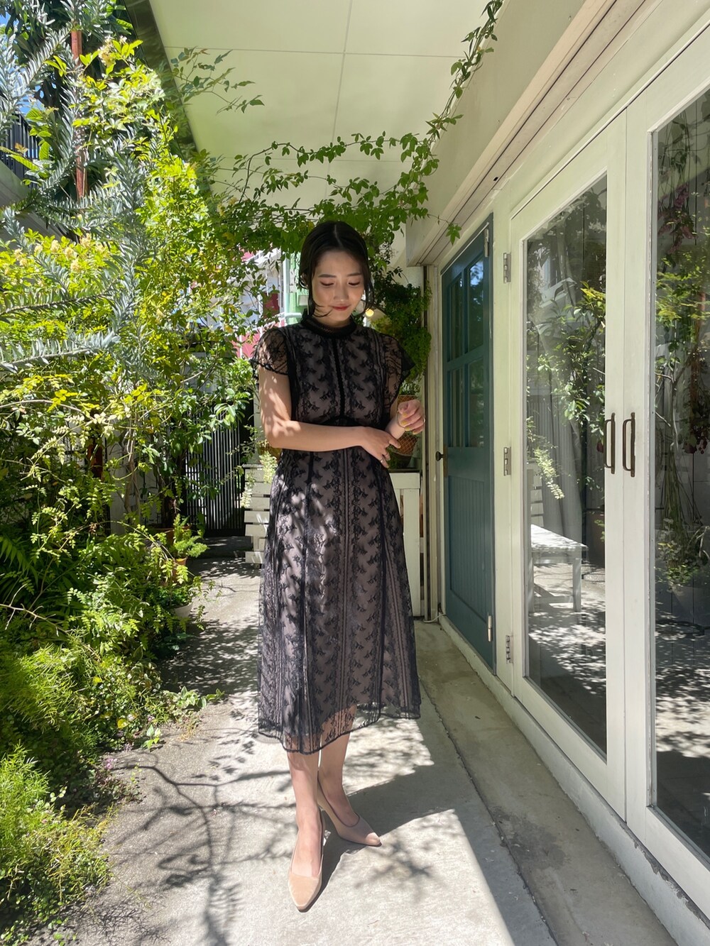 ゴールド系のパンプス、ブラック系のドレスを着用したレディースの夏コーディネートの2枚目の写真