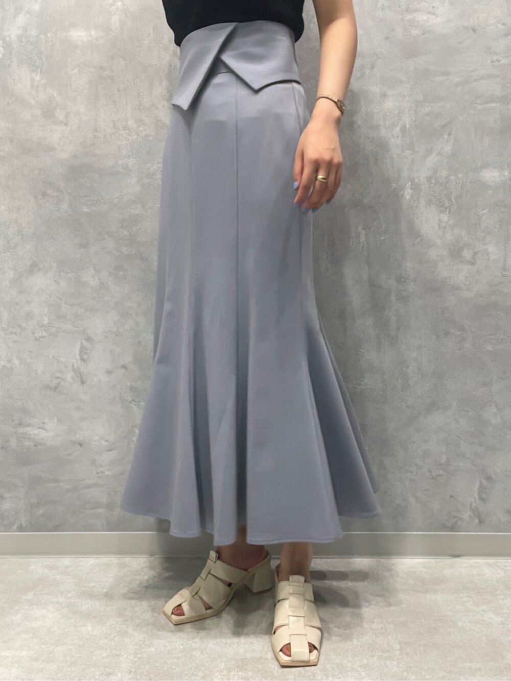 ホワイト系のサンダル、ブラック系のニット/セーター、ブルー系のスカートを着用したレディースの夏コーディネートの8枚目の写真