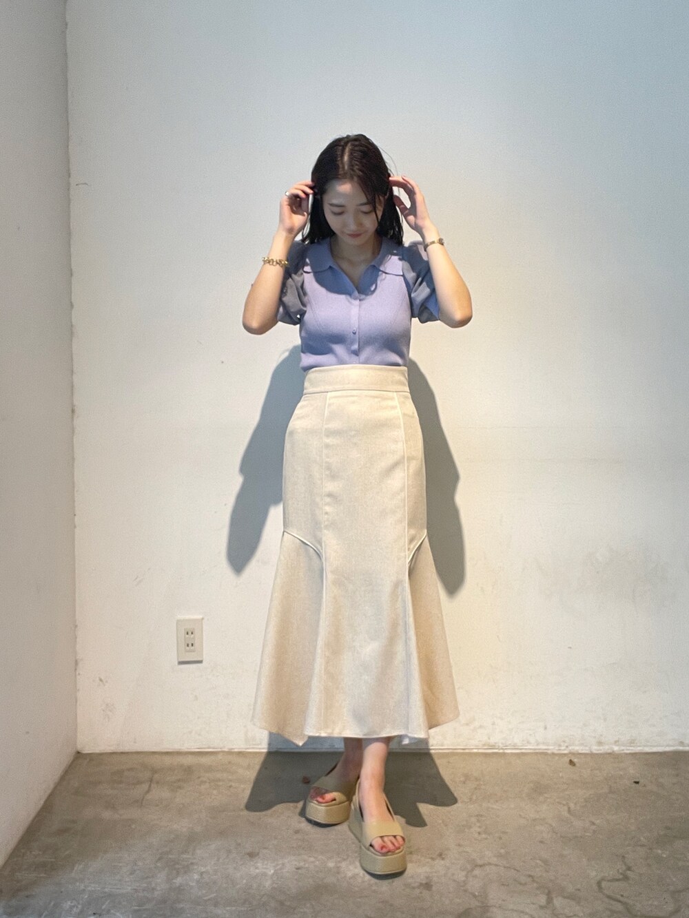 パープル系のニット/セーター、ベージュ系のサンダル、ホワイト系のスカートを着用したレディースの夏コーディネートの3枚目の写真