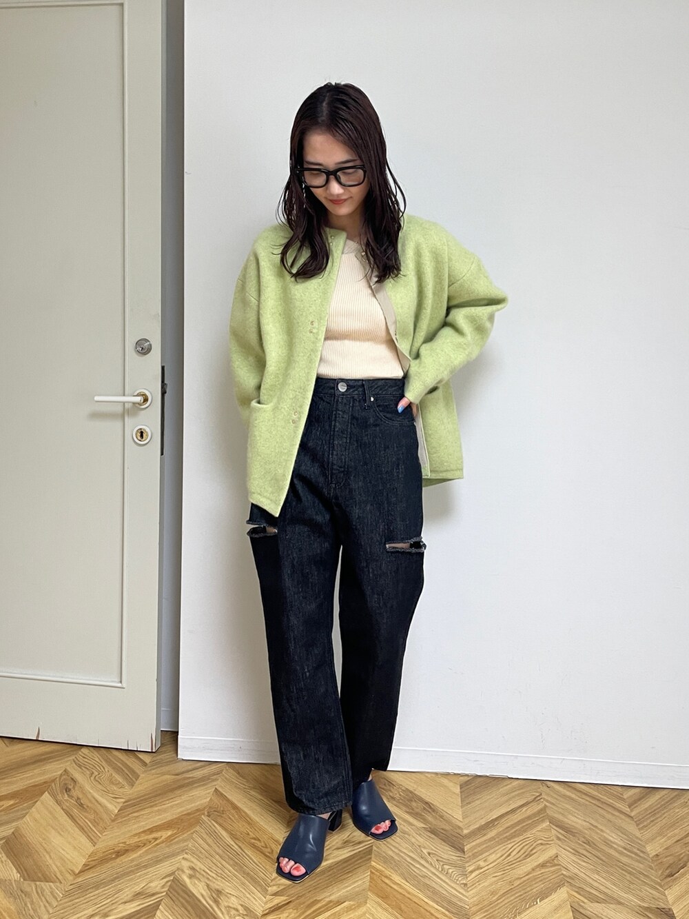 ブラック系のデニムパンツ、ブルー系のサンダル、グリーン系のカーディガン/ボレロを着用したレディースの夏コーディネートの2枚目の写真