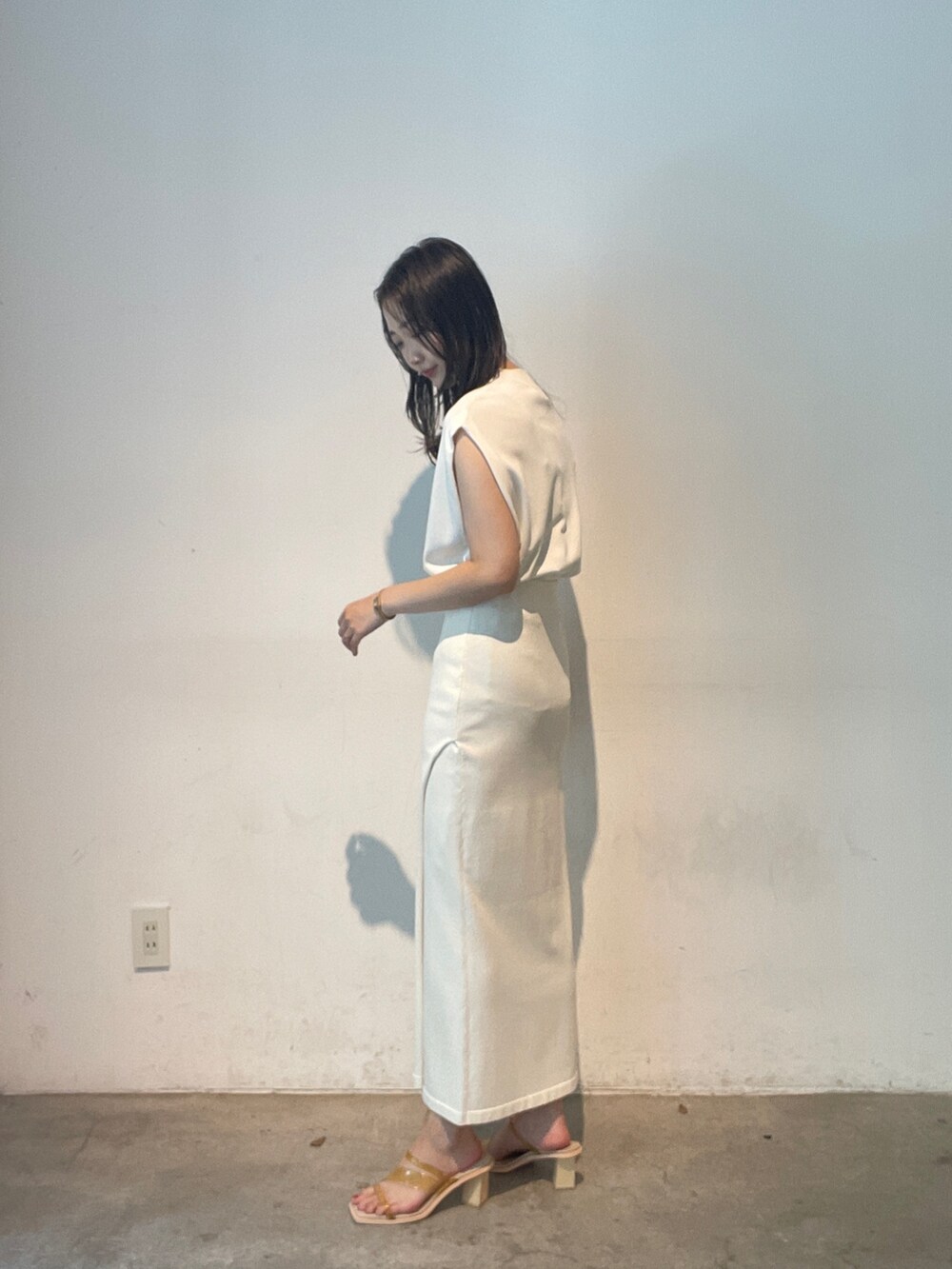 ホワイト系のスカート、ホワイト系のニット/セーター、イエロー系のサンダルを着用したレディースの夏コーディネートの5枚目の写真