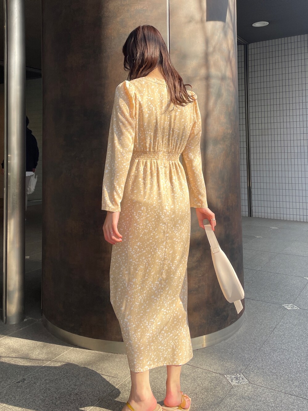 ベージュ系のワンピース、イエロー系のサンダルを着用したレディースの冬コーディネートの4枚目の写真