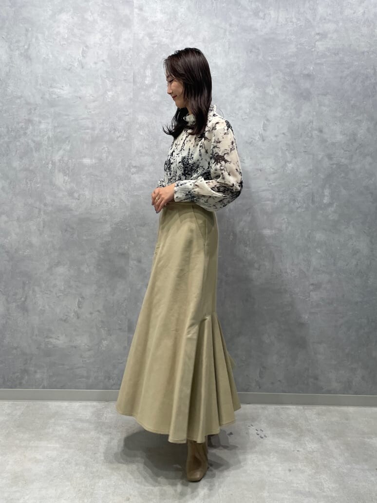 ベージュ系のスカート、グレー系のシャツ/ブラウス、ベージュ系のブーツを着用したレディースの夏コーディネートの5枚目の写真