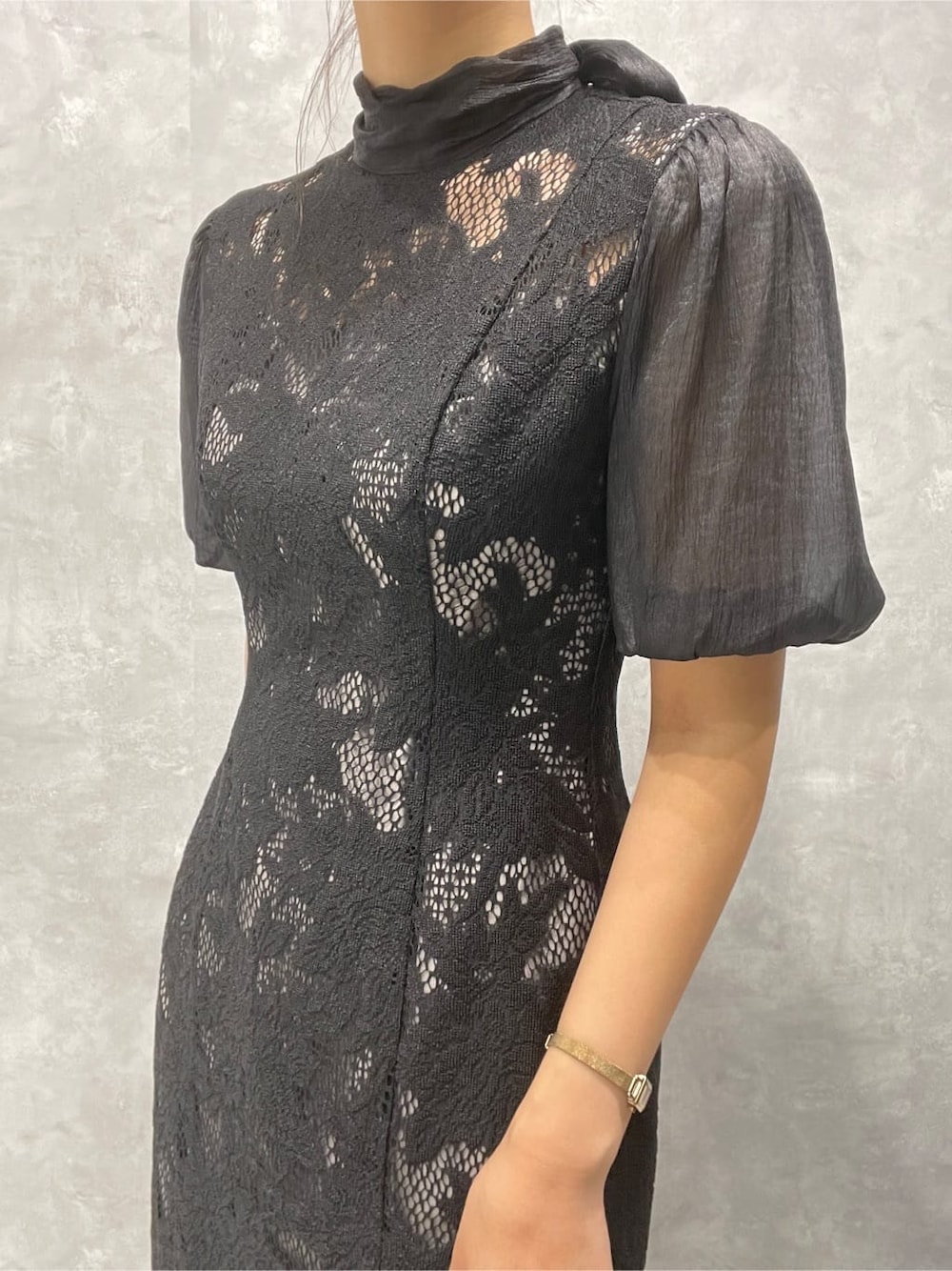 ゴールド系のパンプス、ゴールド系のクラッチバッグ、ブラック系のドレスを着用したレディースの秋コーディネートの7枚目の写真