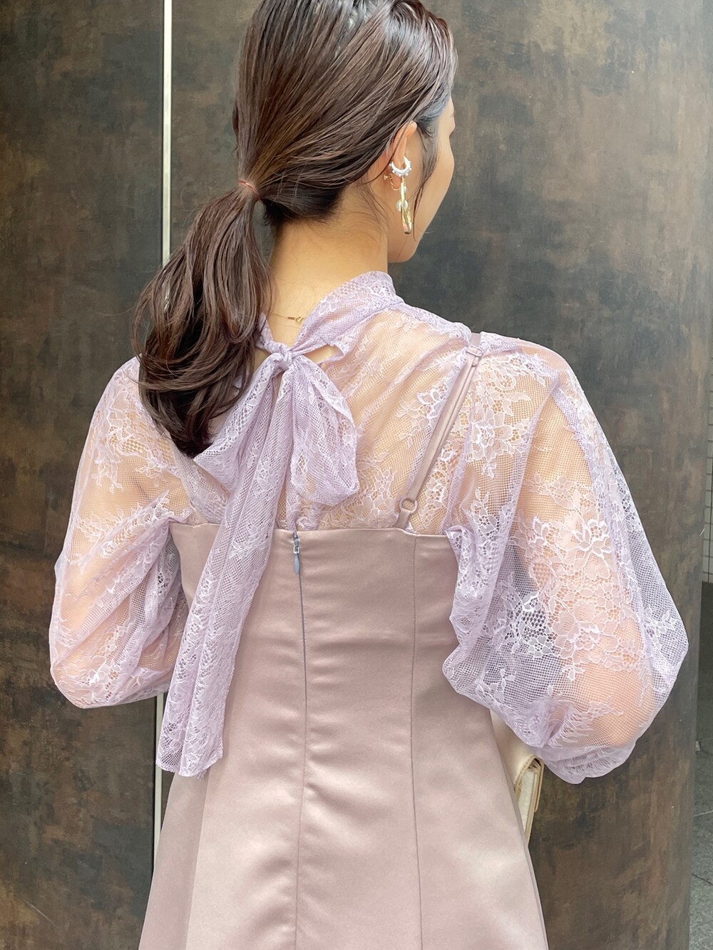 ベージュ系のパンプス、パープル系のドレス、ベージュ系のクラッチバッグを着用したレディースの冬コーディネートの10枚目の写真