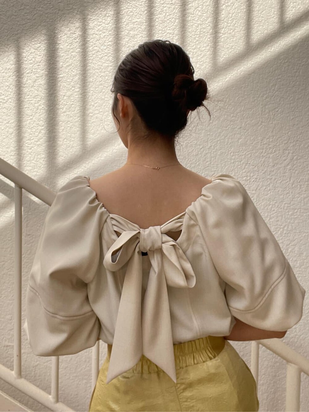 ホワイト系のシャツ/ブラウス、ホワイト系のテーラードジャケット、イエロー系のスカートを着用したレディースの冬コーディネートの9枚目の写真