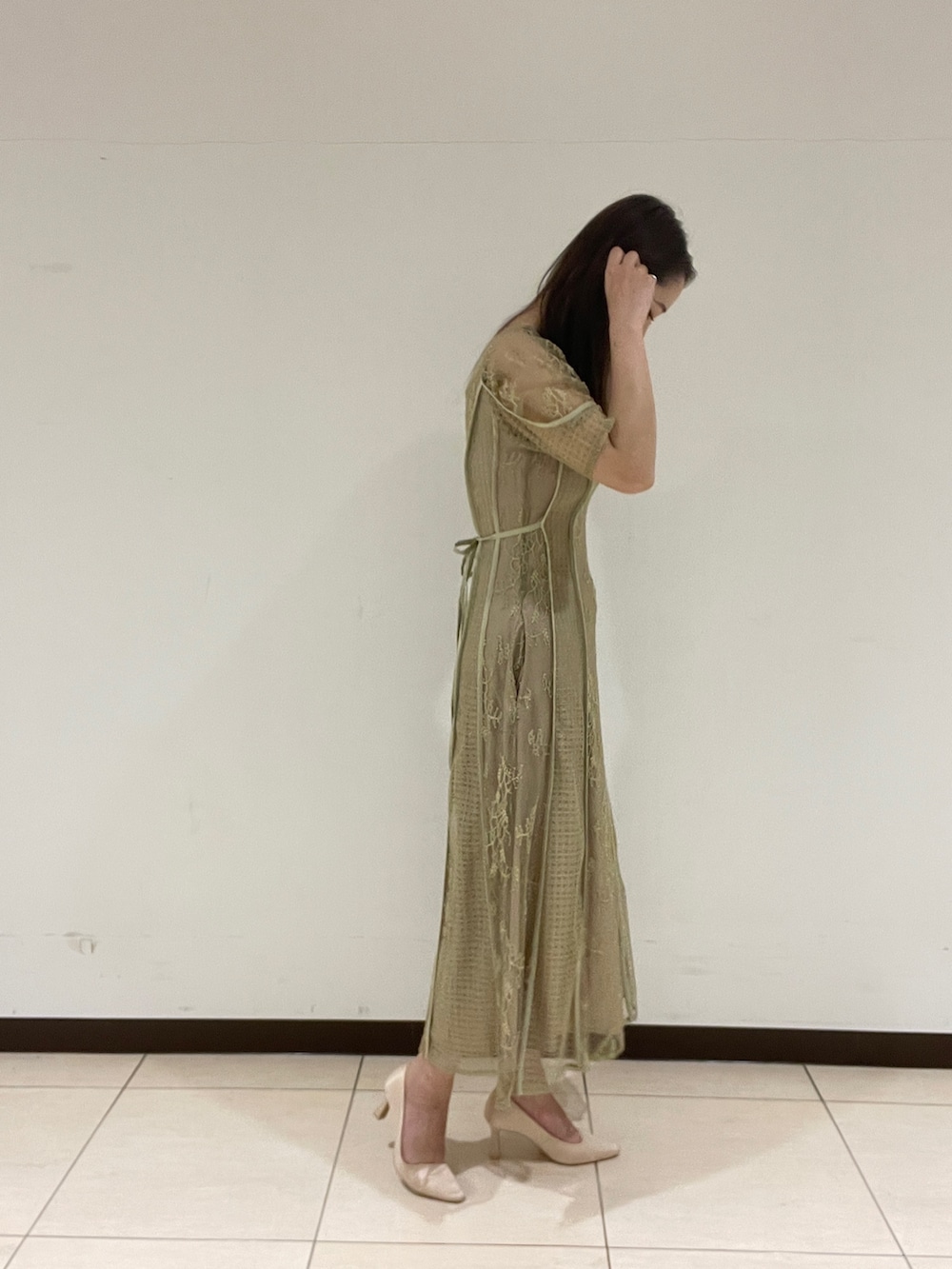 ベージュ系のパンプス、グリーン系のドレスを着用したレディースの春コーディネートの5枚目の写真