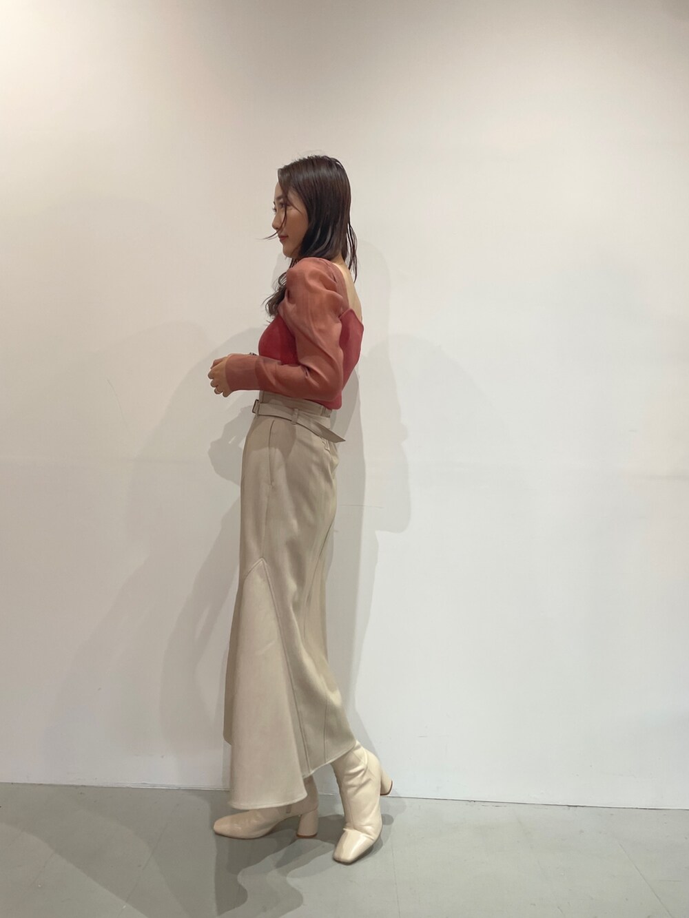 ホワイト系のブーツ、ベージュ系のスカート、ピンク系のニット/セーターを着用したレディースの夏コーディネートの5枚目の写真